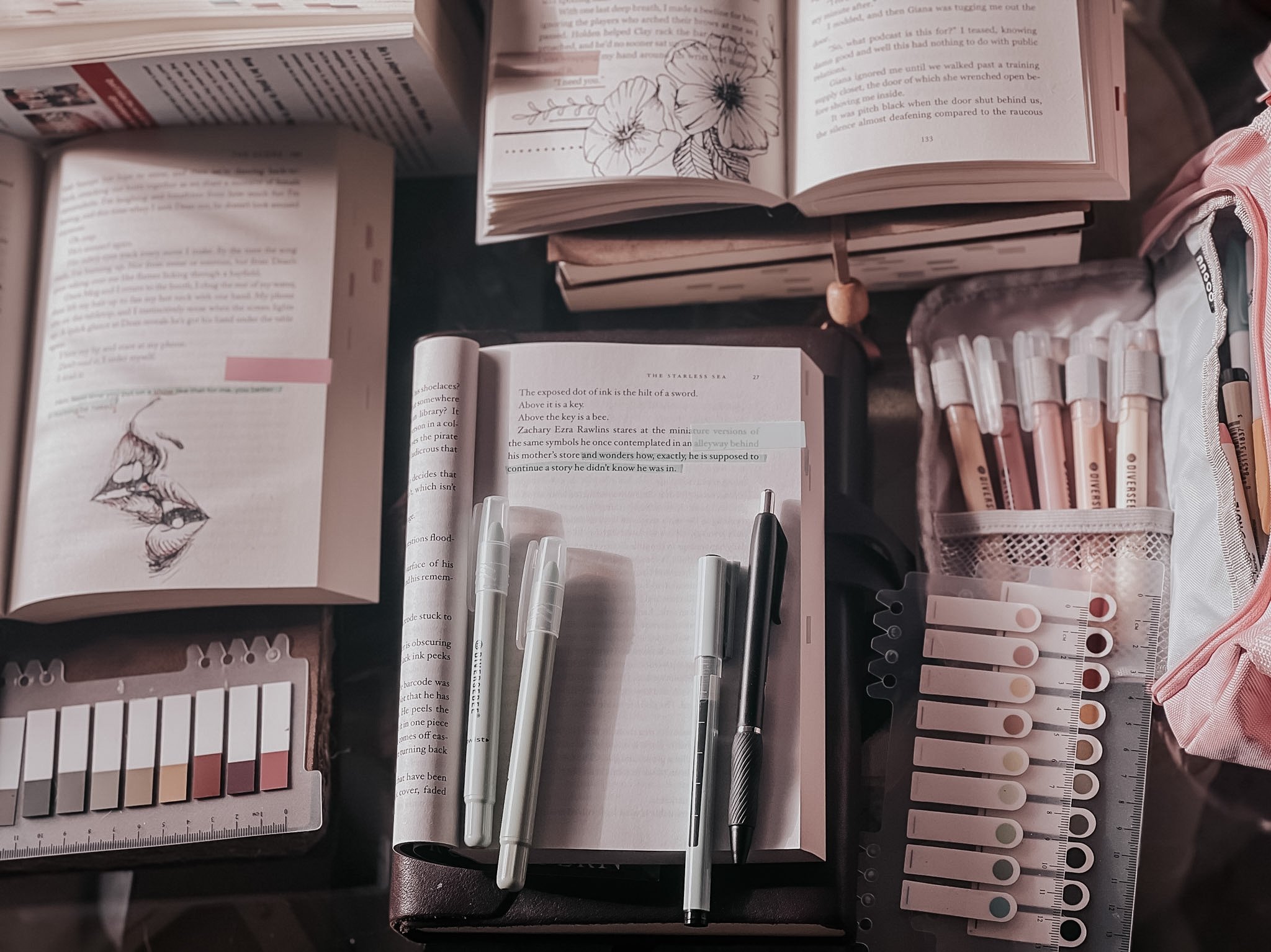 Bookstagram essentials: An image of various annotation supplies, including colorful pens, sticky notes, and bookmarks, alongside stacks of books. Learn how to create engaging content and build a vibrant book-loving community.